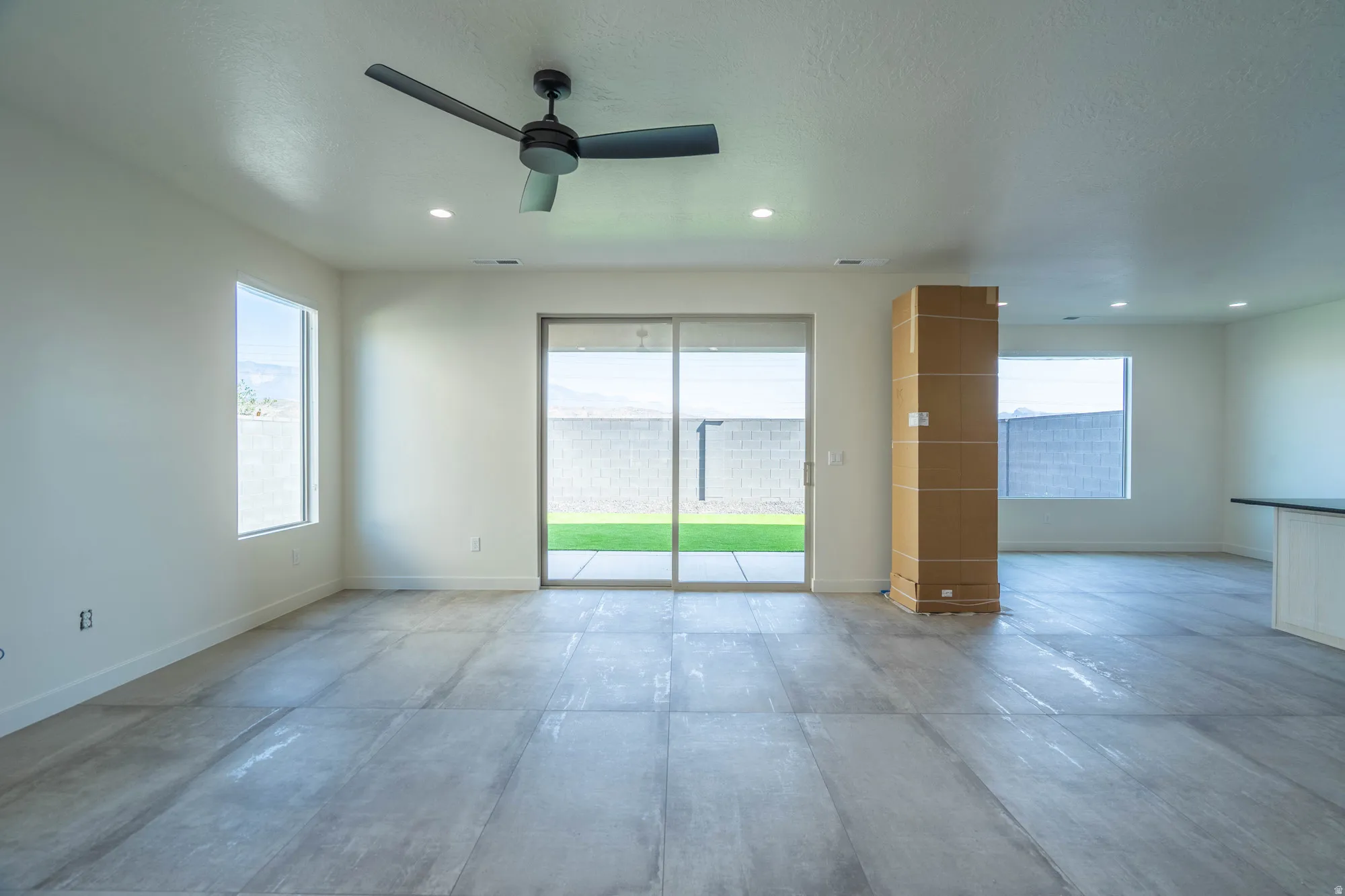 Expansive interior with large format tile flooring, recessed lighting, and a ceiling fan