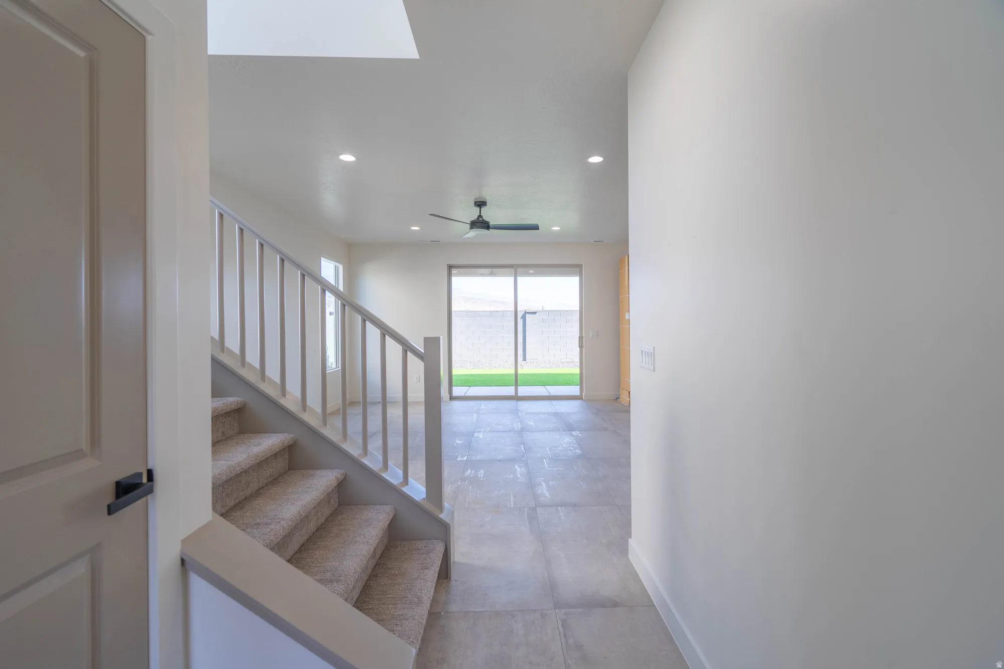 Recessed lighting, light-toned walls, and a ceiling fan