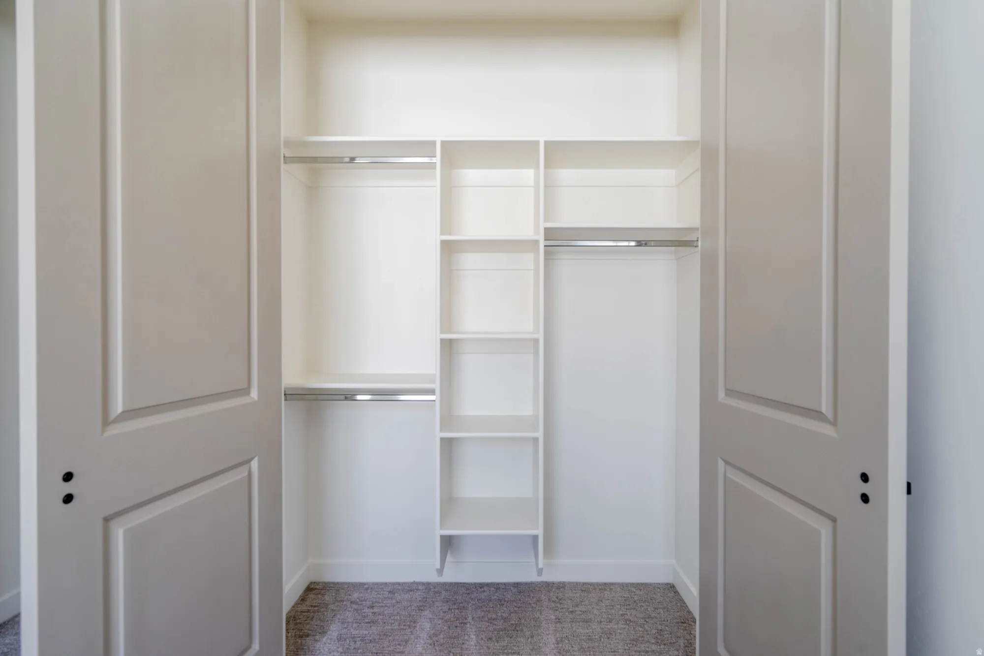 Built-in closet system with shelving, integrated hanging rods, and paneled bifold doors