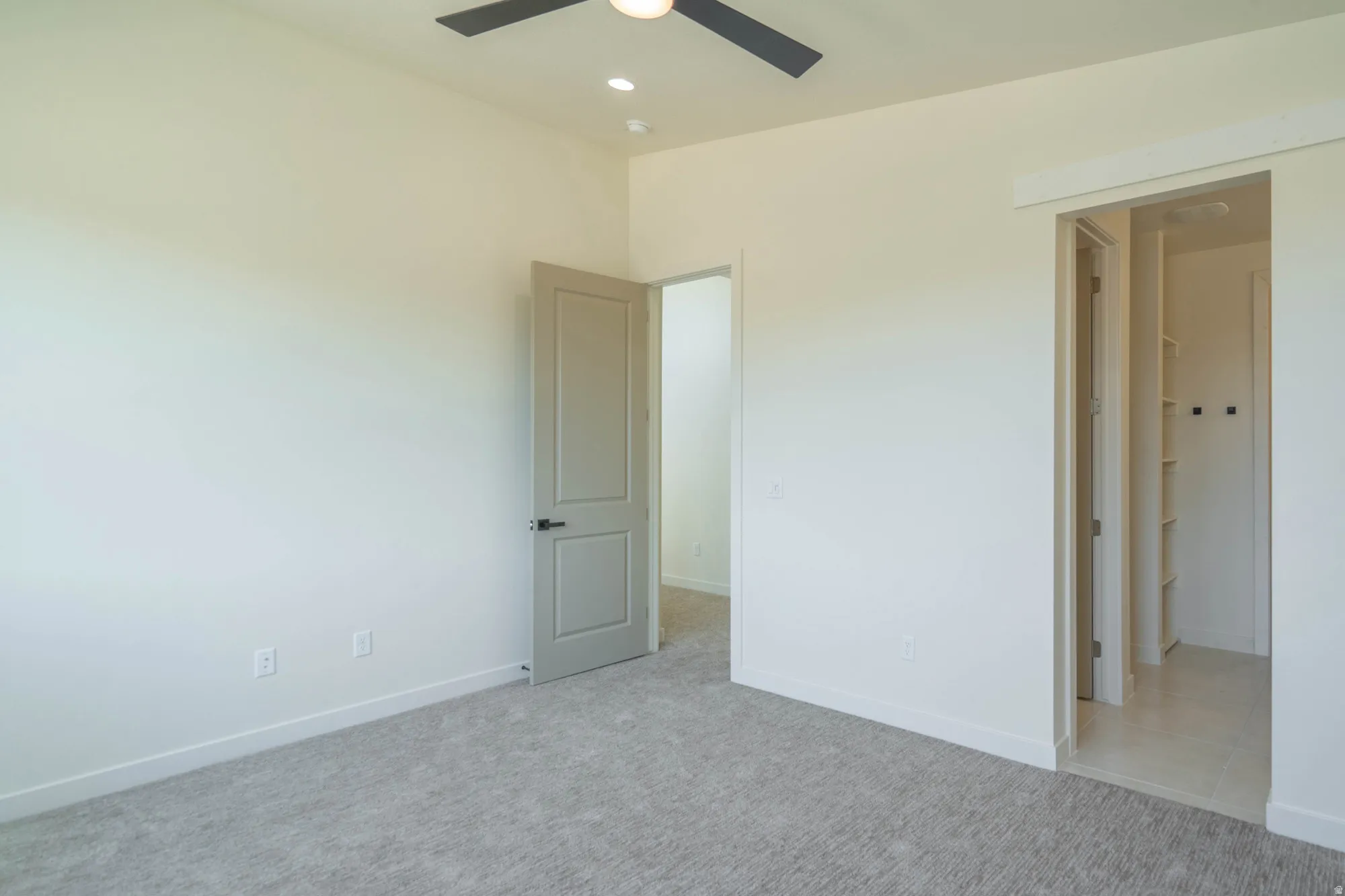 Carpeted interior with high ceilings, recessed lighting, and a ceiling fan