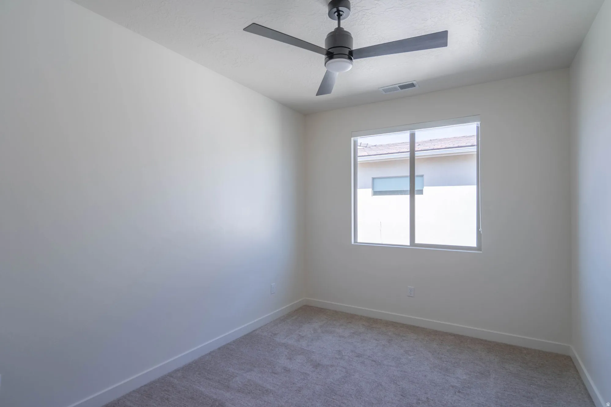 Carpeted flooring, white walls, white trim, rectangular window, ceiling fan with integrated lighting