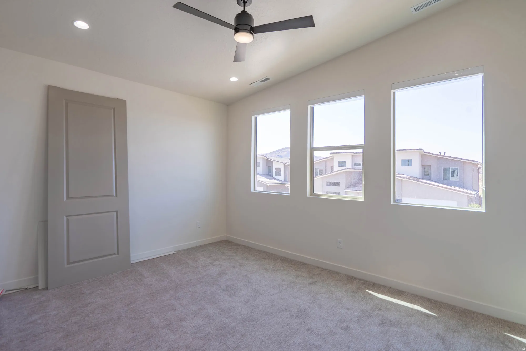 Sloped ceiling with recessed lighting and a ceiling fan