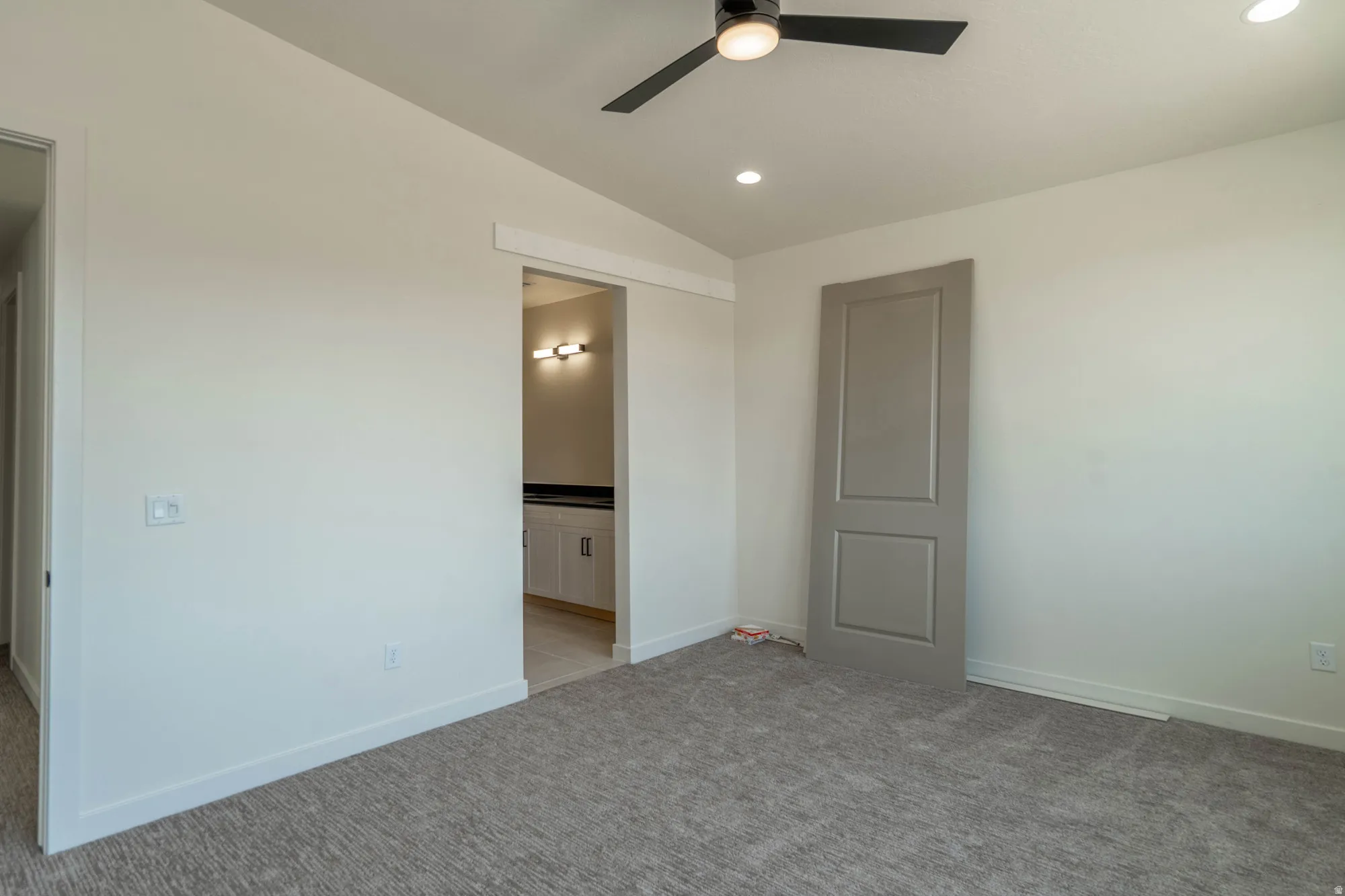 Recessed lighting, ceiling fan with light, neutral tone walls, gray carpet, and a pocket door