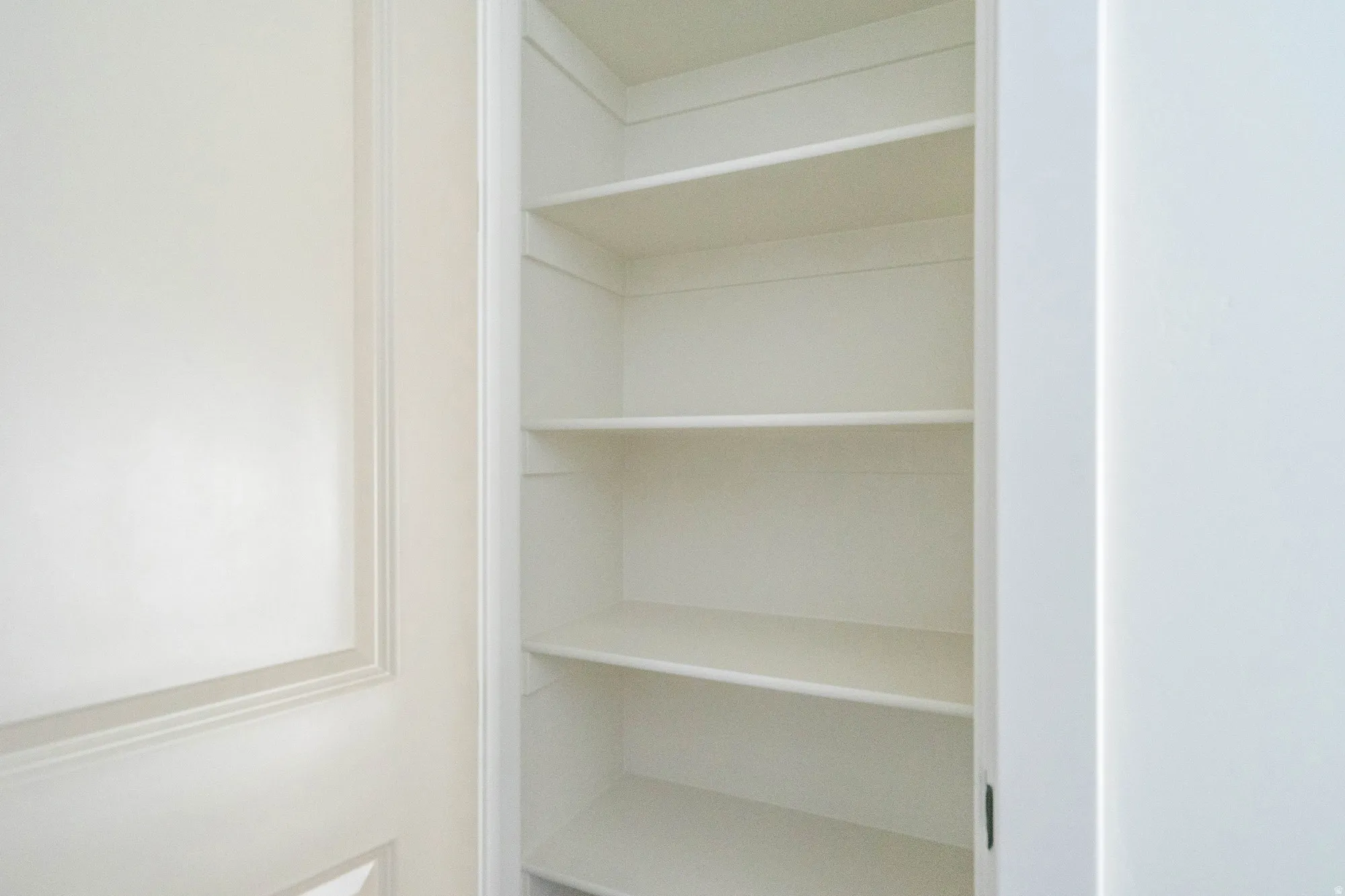 Built-in shelving with multiple levels, white finish, and integrated into a wall recess
