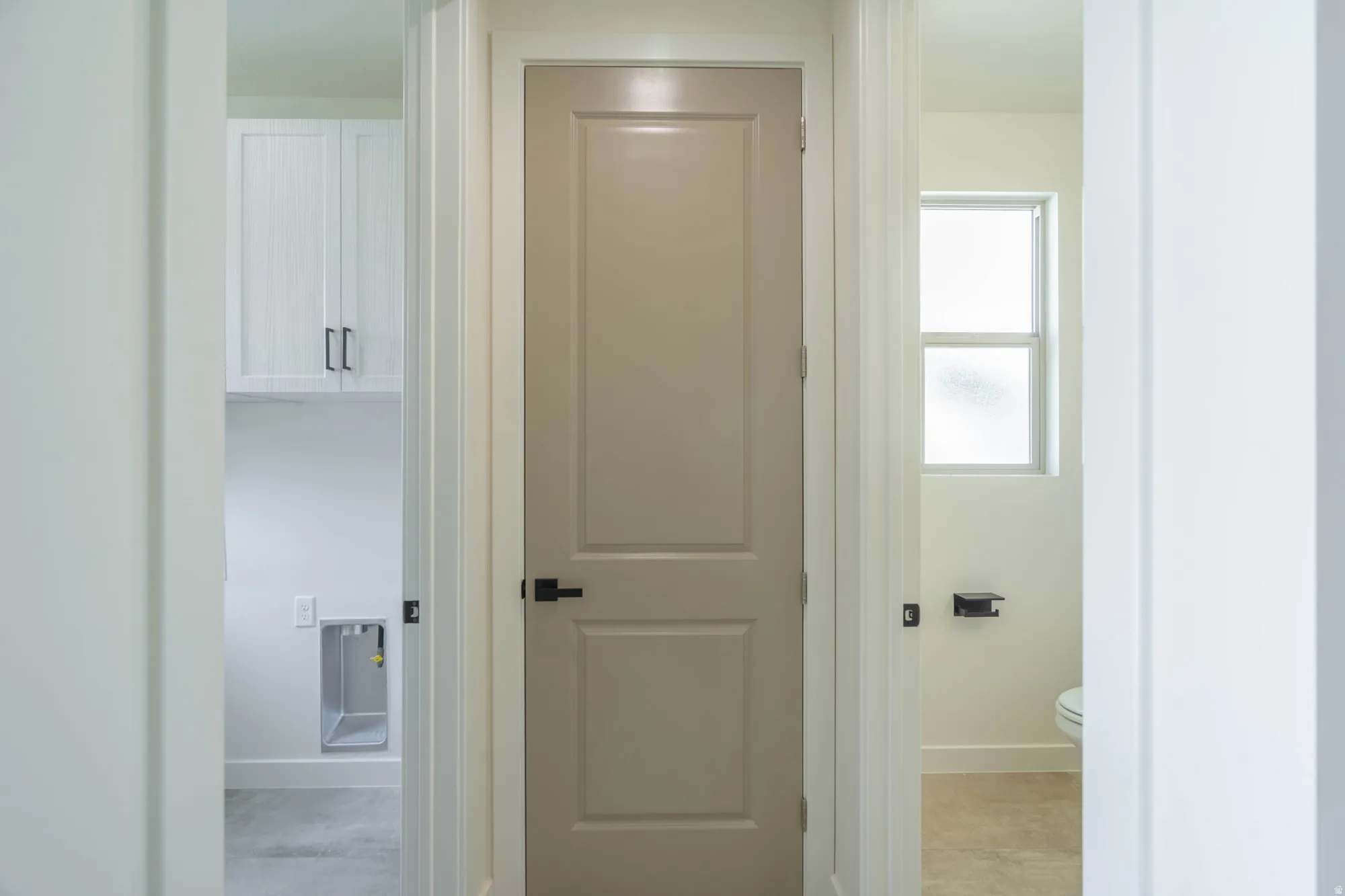 White shaker-style upper cabinetry with dark hardware