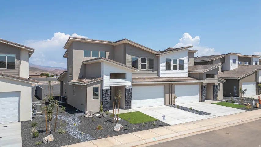 Contemporary exterior with multiple roof lines, stone accents, attached two-car garage, and a concrete driveway