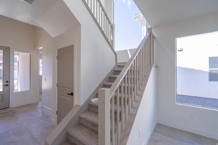 Staircase with carpeted treads and painted wood balusters