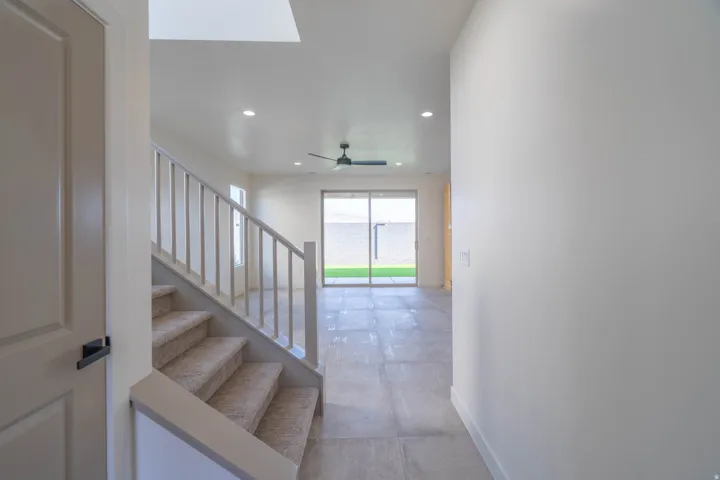 Recessed lighting, light-toned walls, and a ceiling fan