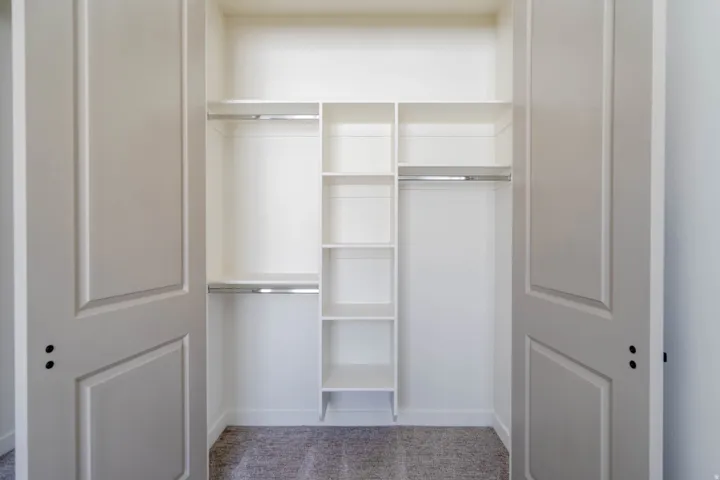 Built-in closet system with shelving, integrated hanging rods, and paneled bifold doors