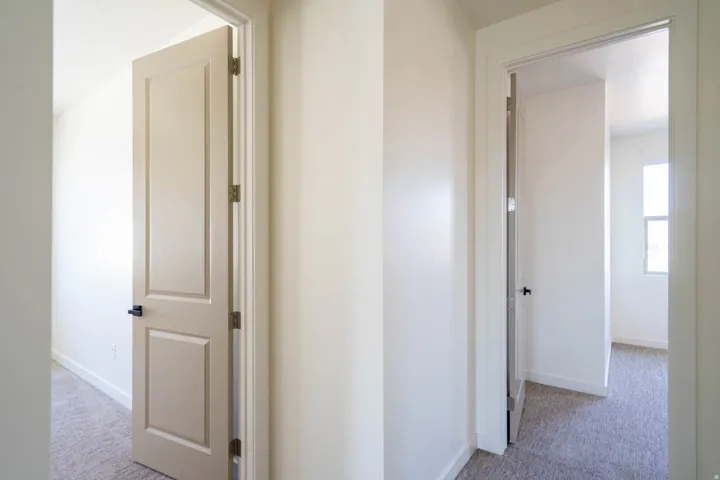 Neutral wall colors, white trim, and light carpeting throughout