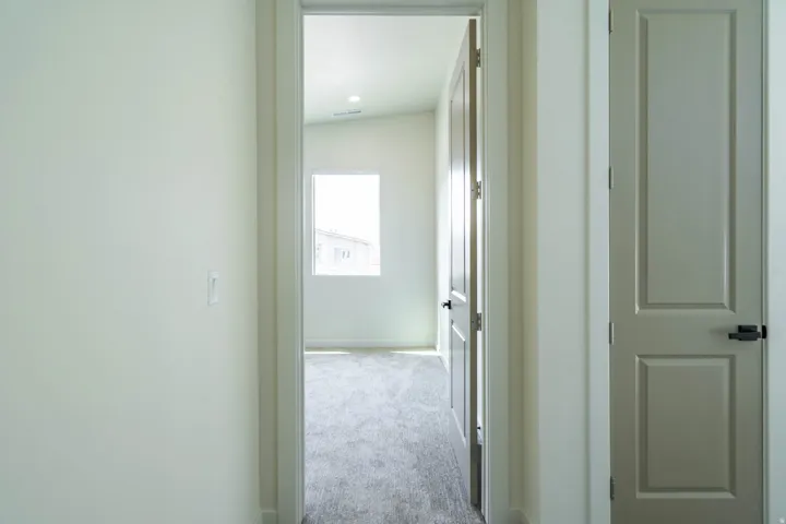 Neutral wall colors, paneled interior doors, black hardware, and gray carpeting