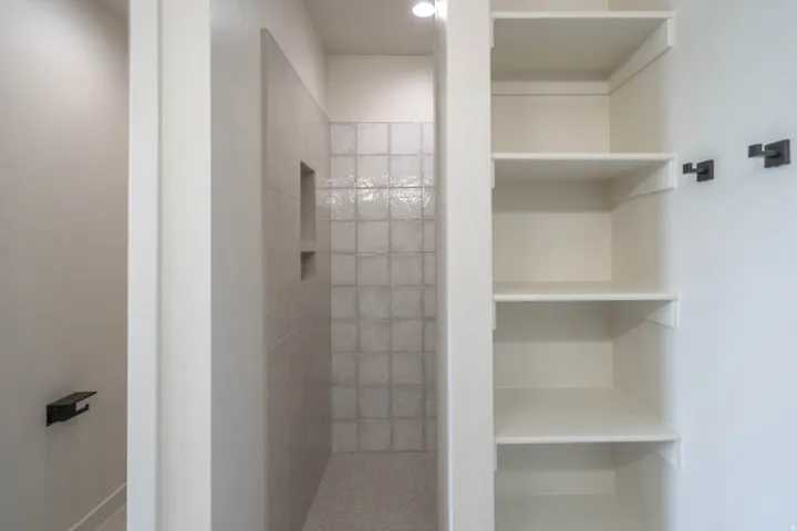 Walk-in shower with tiled walls, integrated niche, and a contrasting tiled floor