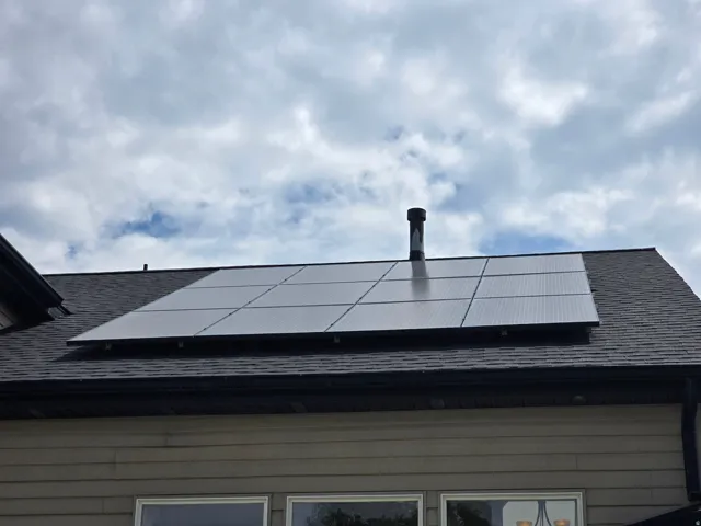 Roofline featuring solar panel array and asphalt shingles