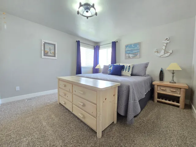 Corner windows with blinds, carpeted flooring, and a flush mount light fixture
