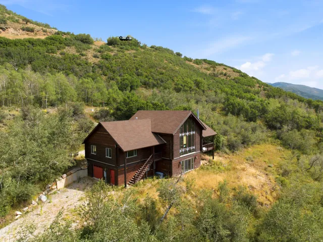Brown-sided home with a prominent pitched roof and a multi-level deck