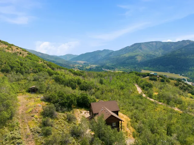 Property situated on a hillside with mountain scenery, surrounded by extensive natural vegetation and trees