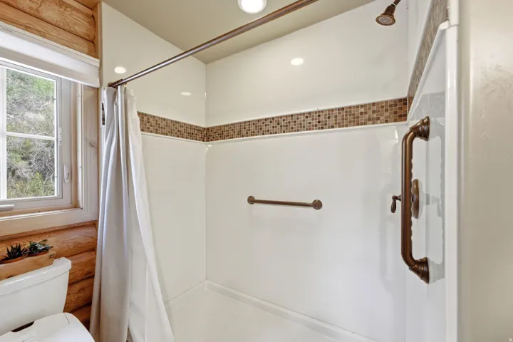 Shower with mosaic tile accent, recessed lighting, and bronze-finish fixtures