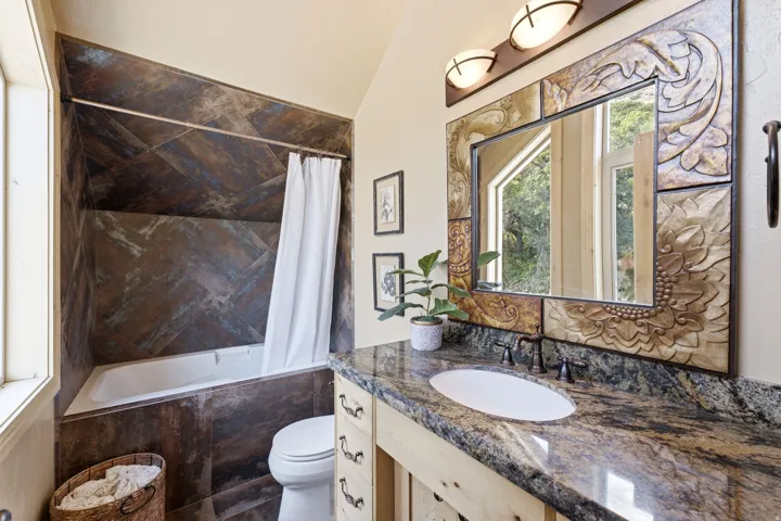 Bathroom with a built-in tub and patterned tile surround