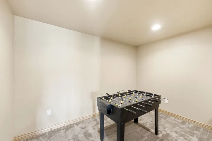 Recessed ceiling lighting, neutral wall paint, and gray textured carpeting create a versatile interior space