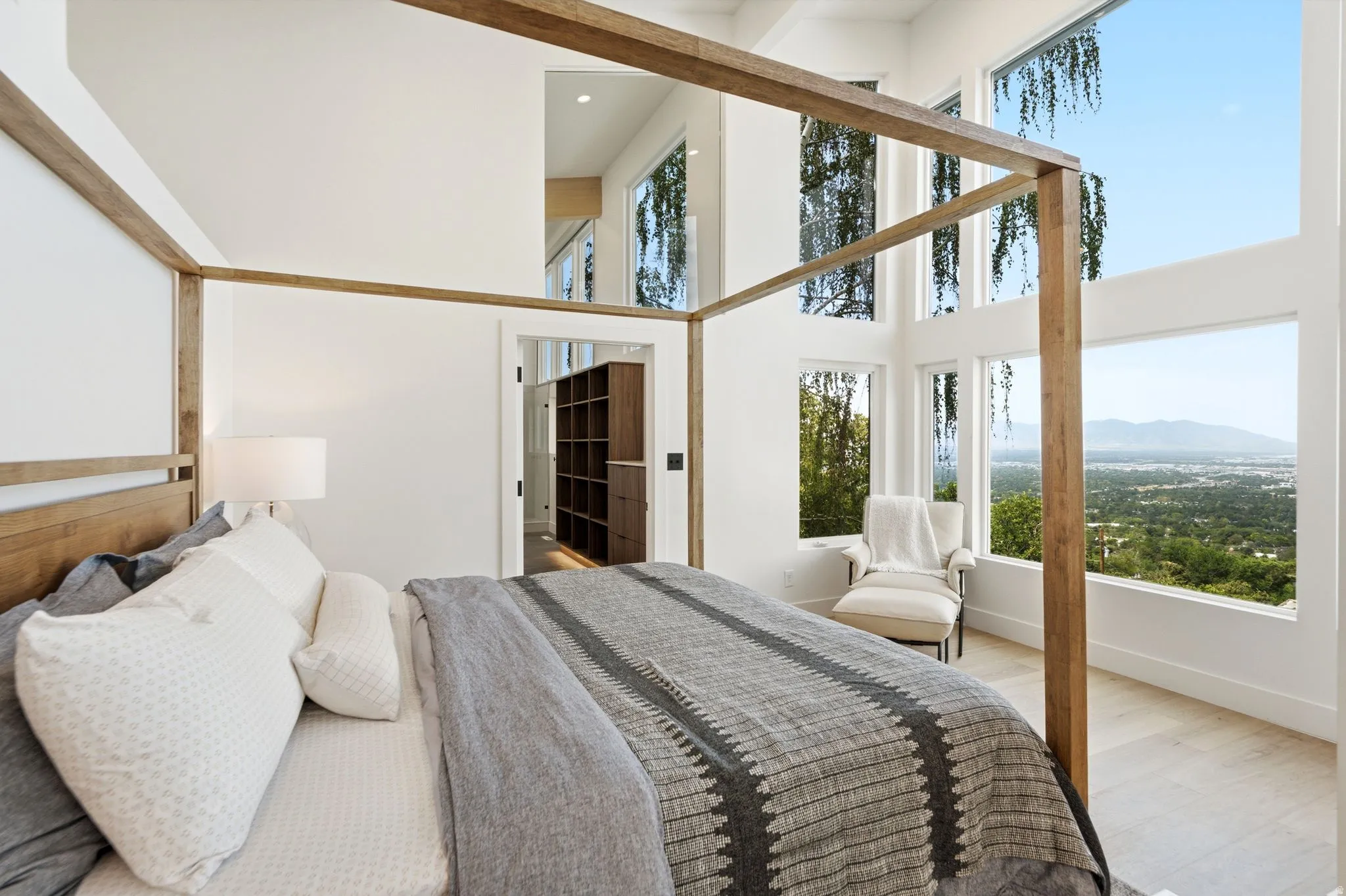 Vaulted ceilings, expansive window array, wood-finish flooring, built-in shelving, and recessed lighting