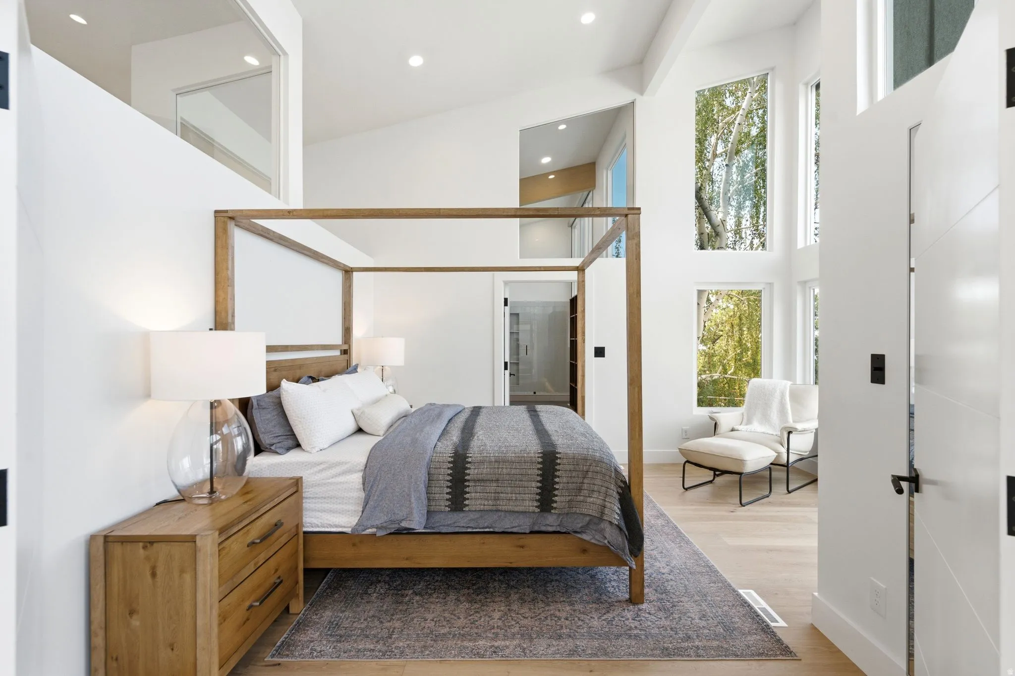Vaulted ceilings, expansive windows, recessed lighting, and light wood-finish flooring