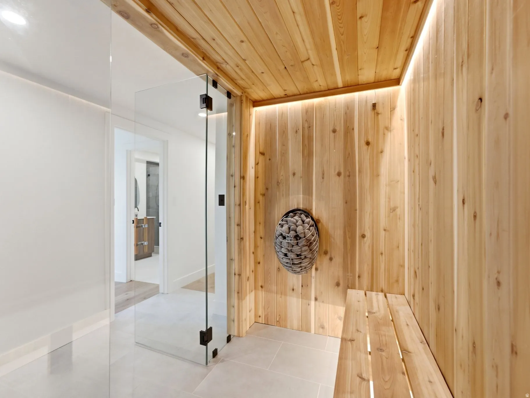 Custom sauna with wood paneling, wood bench, and integrated lighting