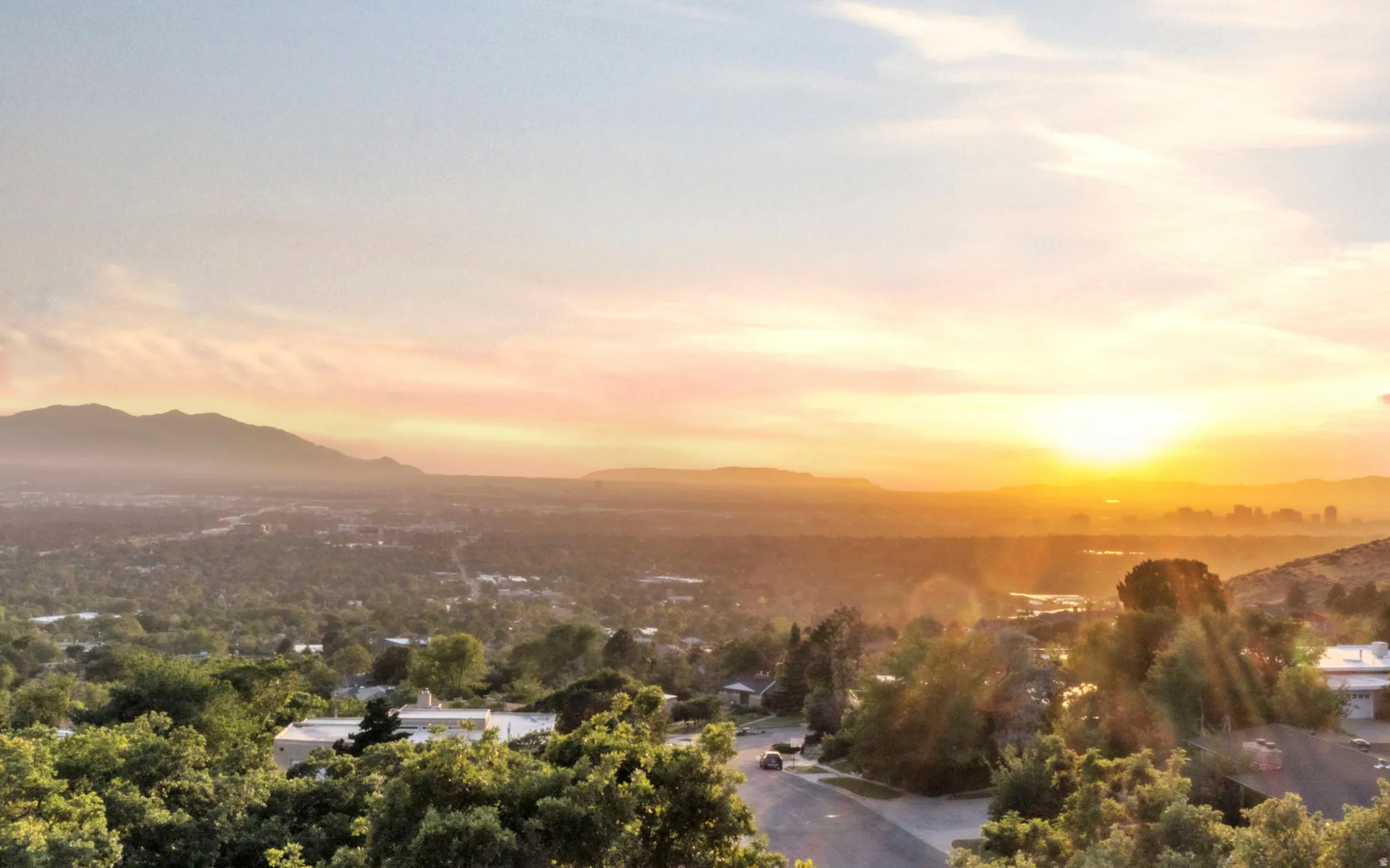 Distant mountain range and cityscape under a vibrant sunset