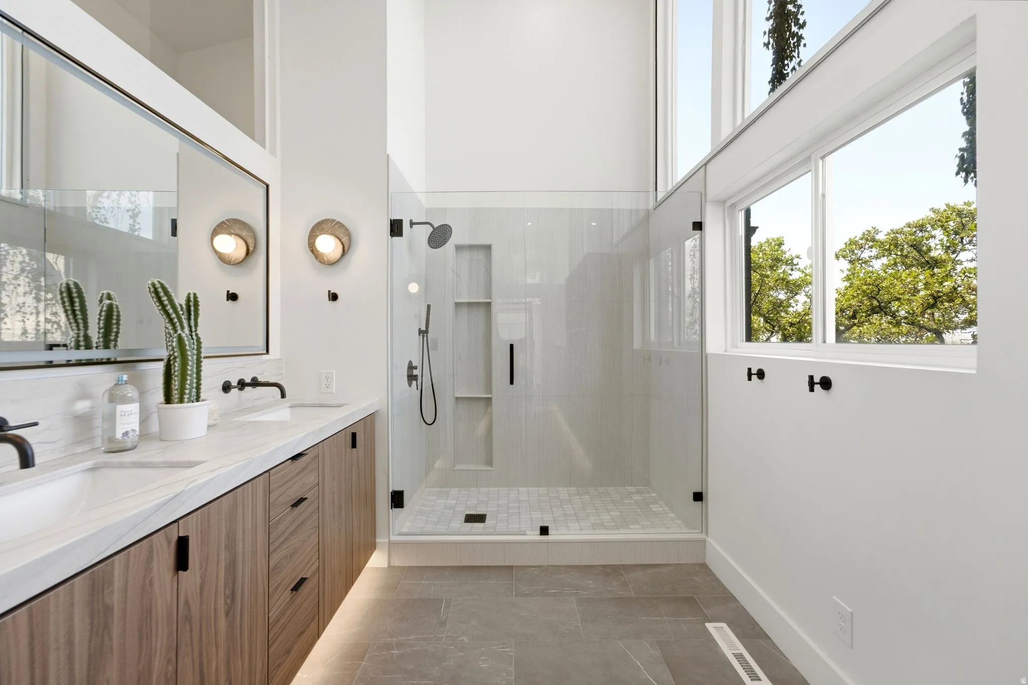 Dual vanity with undermount sinks, wood-finish cabinetry, and stone countertops