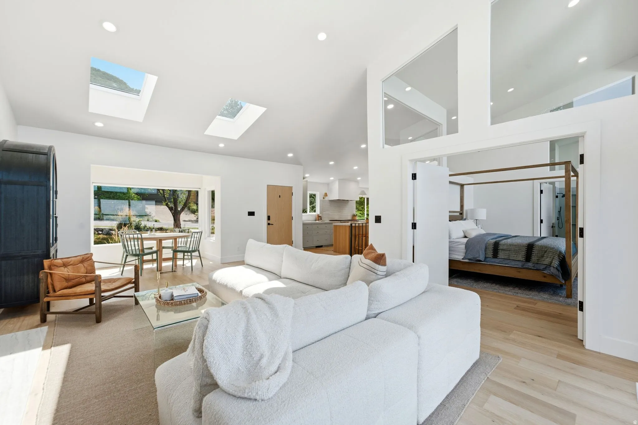 Vaulted ceilings, skylights, recessed lighting, wood-finish flooring, and a large window