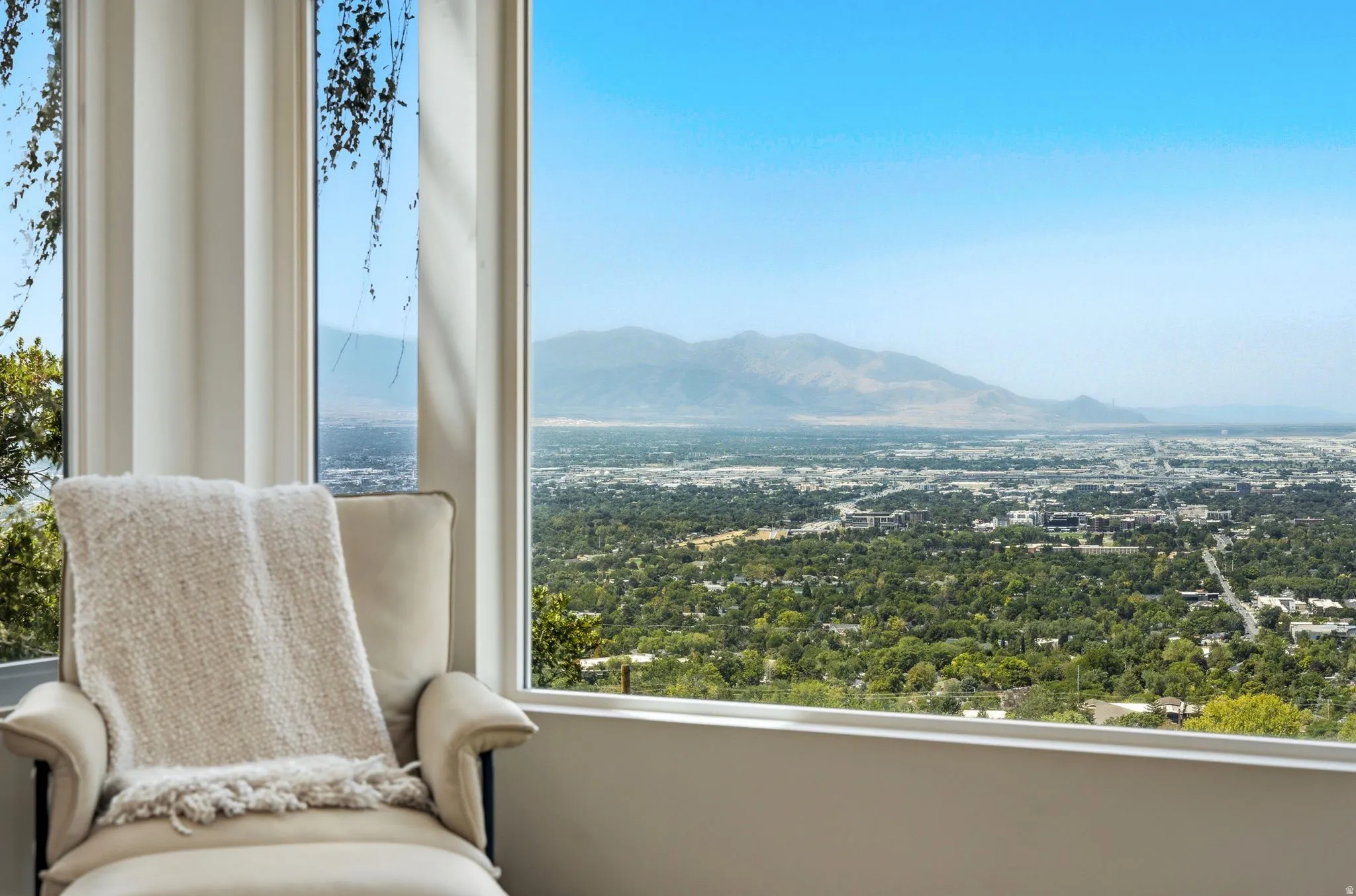 Floor-to-ceiling windows with expansive city and mountain scenery
