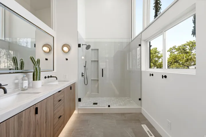 Dual vanity with undermount sinks, wood-finish cabinetry, and stone countertops