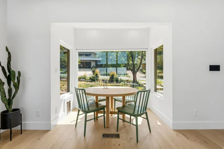 Recessed alcove with expansive windows, light wood-finish flooring, and white painted walls