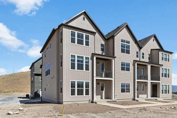 Contemporary multi-level townhome architecture with mixed siding and dark trim