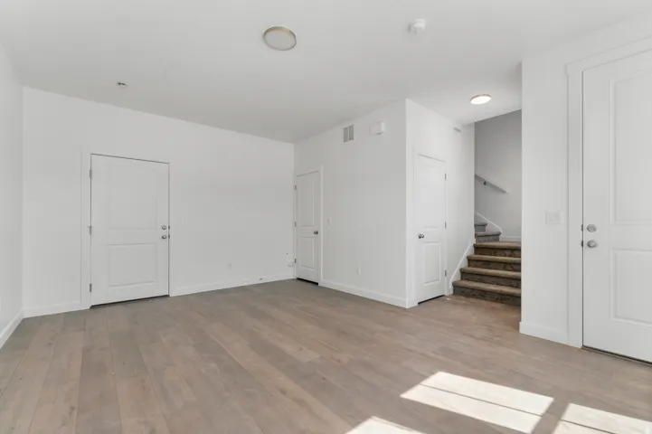Wood-finish flooring throughout, bright white walls, and recessed lighting