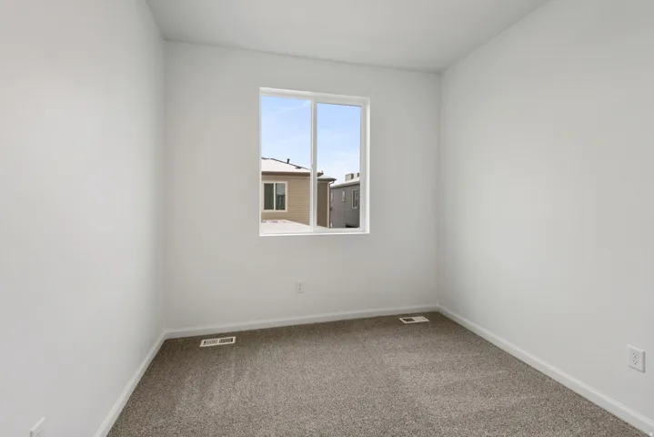 Neutral wall paint, framed window, and carpeted flooring