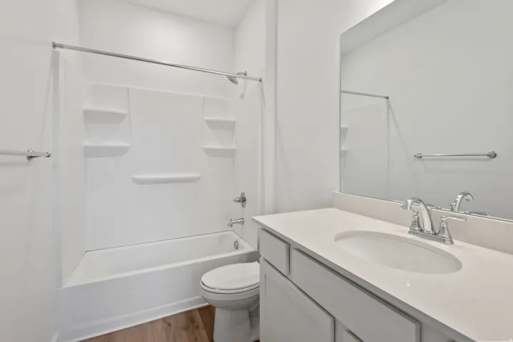 White vanity with an integrated sink, polished chrome faucet, and expansive mirror