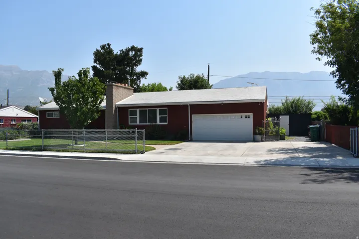 Red exterior with white trim, attached two-car garage, and a concrete driveway