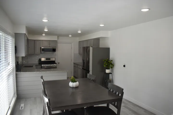 Kitchen featuring grey cabinetry, stainless steel appliances, and recessed lighting
