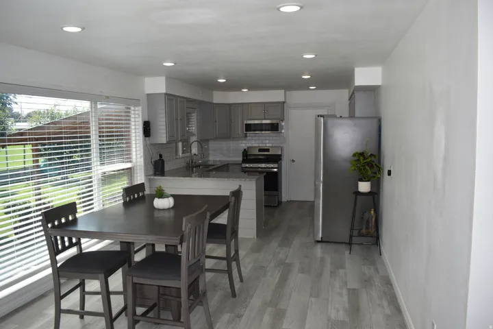 Kitchen featuring gray cabinetry, stainless steel appliances, and a tiled backsplash