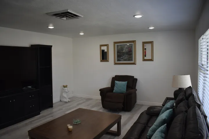 Recessed lighting, wood-finish flooring, and white walls