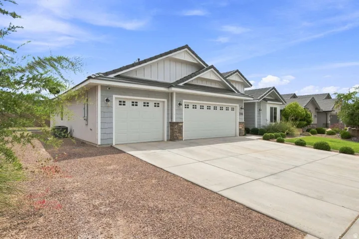 Exterior featuring gray siding, stone accents, and a tile roof
