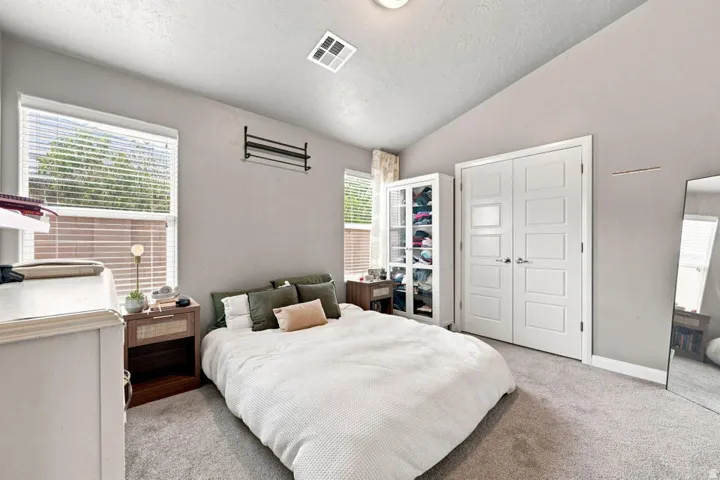 Vaulted ceiling, dual windows with blinds, recessed lighting, and soft grey wall color