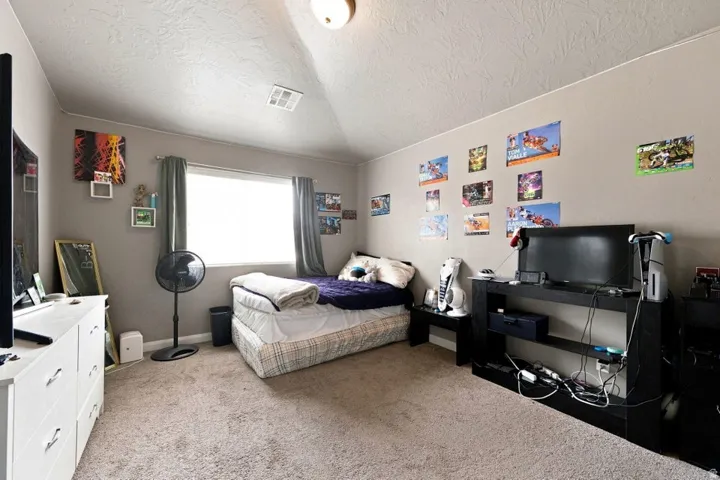 Neutral tone wall paint, textured ceiling, and carpeted flooring