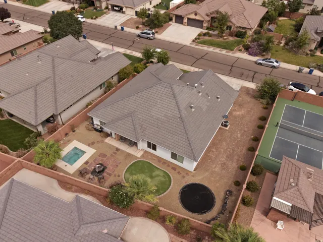 Terracotta tile roof, rear patio, inground pool, manicured lawn, and adjacent tennis court