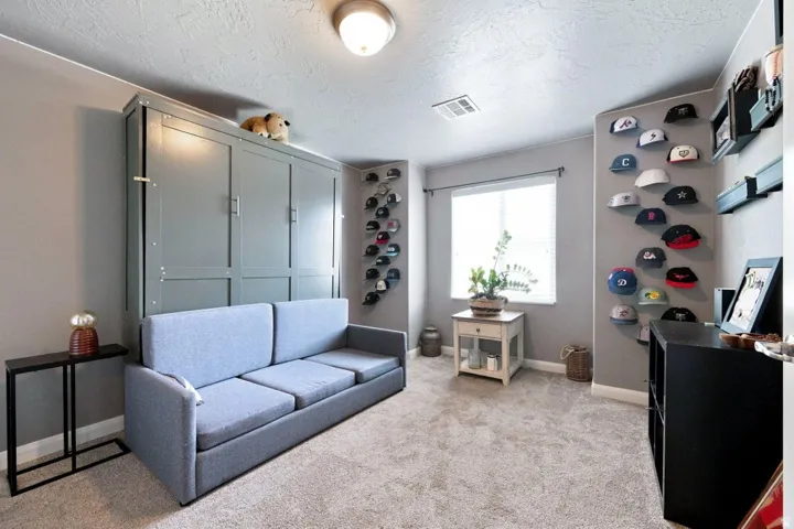 Built-in wall unit with paneling, window with blinds, overhead lighting, and wall-to-wall carpeting