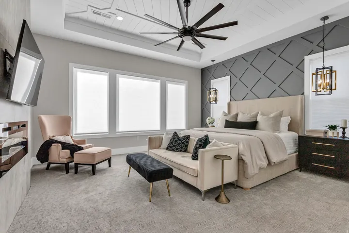 Tray ceiling with wood-paneled detailing and ceiling fan