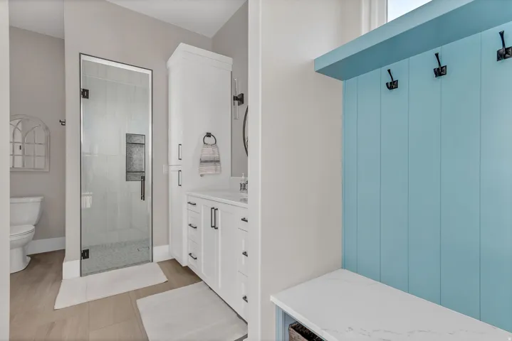 Bathroom featuring a glass-enclosed shower, white vanity cabinetry with a countertop, and a built-in storage cabinet