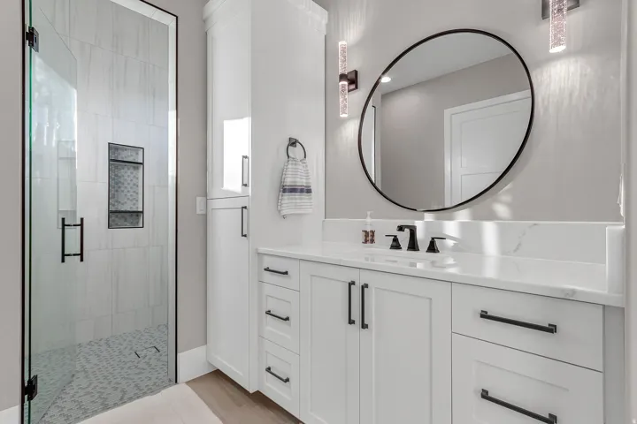 Glass-enclosed shower with tile surround and built-in niche
