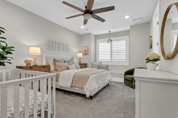 Recessed lighting, wood-finish ceiling fan, window with white plantation shutters, and light-tone carpeting