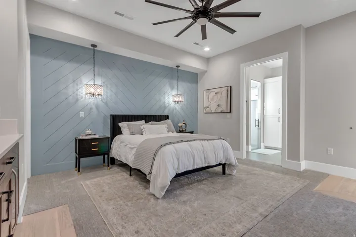 Accent wall featuring a chevron pattern, suspended pendant lighting fixtures, recessed ceiling lighting, a ceiling fan, and built-in cabinetry in the adjacent space